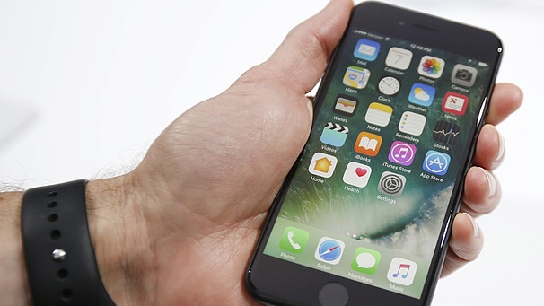 Ein Journalist hält das Apple iPhone 7 in der Hand | Bild: picture-alliance/dpa
