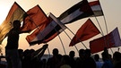 Demonstranten schwenken die Fahnen der am Arabischen Frühling beteiligten Länder | Bild: picture-alliance/dpa