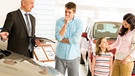 Car dealer offering a vehicle to young couple | Bild: picture-alliance/dpa