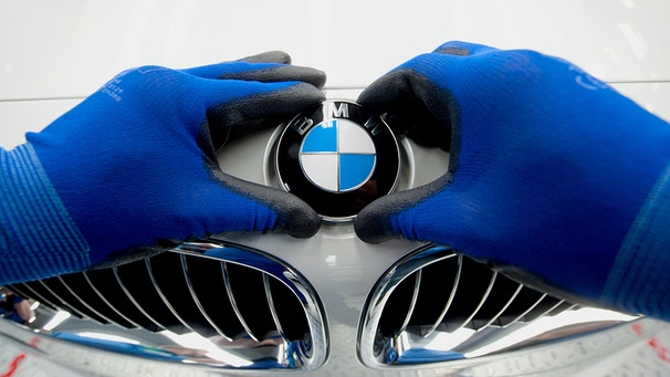 BMW-Logo wird auf Motorhaube von 3er BMW angebracht | Bild: picture-alliance/dpa