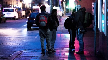Tagelöhner stehen abends an einer Straßenecke | Bild: picture-alliance/dpa | Alexander Heinl