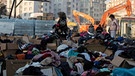 Menschen suchen brauchbare Kleider in Kartons mit Kleiderspenden | Bild: Reuters I Umit Bektas
