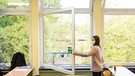 Eine Schülerin öffnet in einer Klasse das Fenster.  | Bild: dpa-Bildfunk