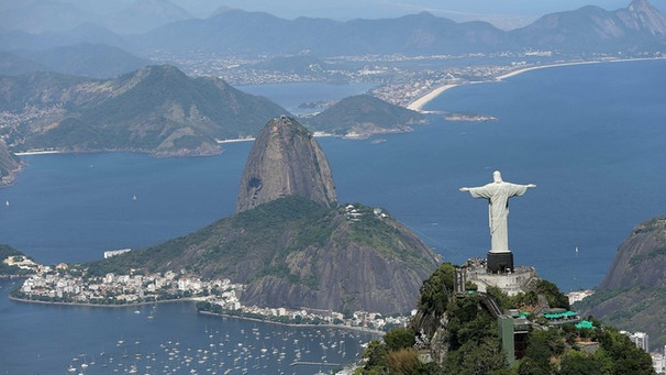 Picture taken shows an aerial view of the Christ the Redeemer (Cristo Redentor) statue atop Corcovado Mountain overlooking the Sugarloaf Mountain (Pao de Acucar hill, C) in Rio de Janeiro, Brazil.  | Bild: picture-alliance/dpa