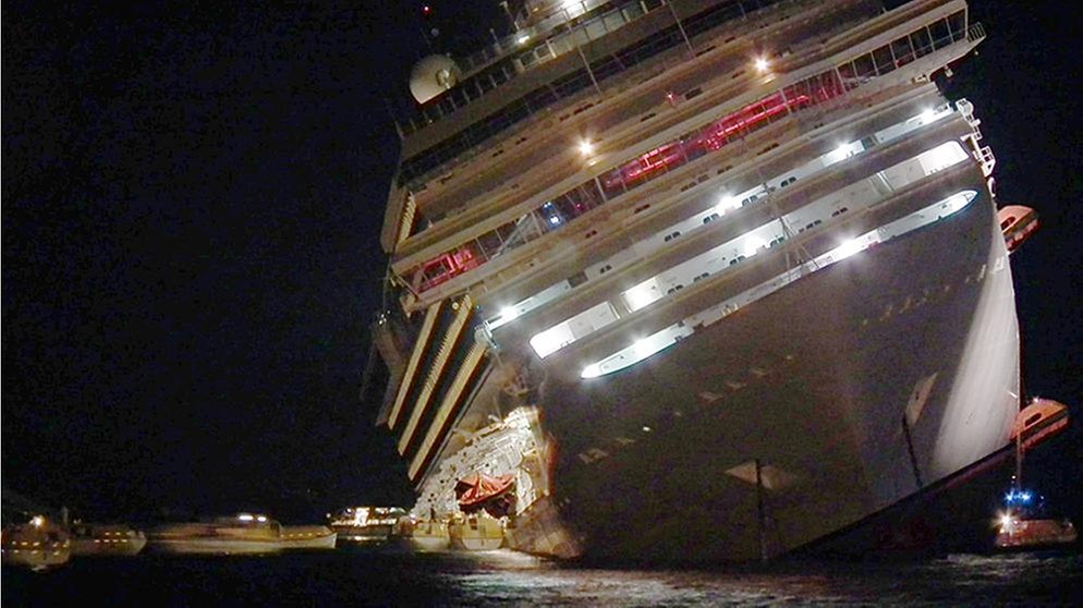 Die Costa Concordia liegt in der Nacht mit Schlagseite vor der Insel Giglio im Wasser | Bild: picture-alliance/dpa