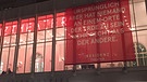 Ein Transparent hängt über dem Eingang des Residenztheaters in Münchner  | Bild: BR/Christine Gaupp