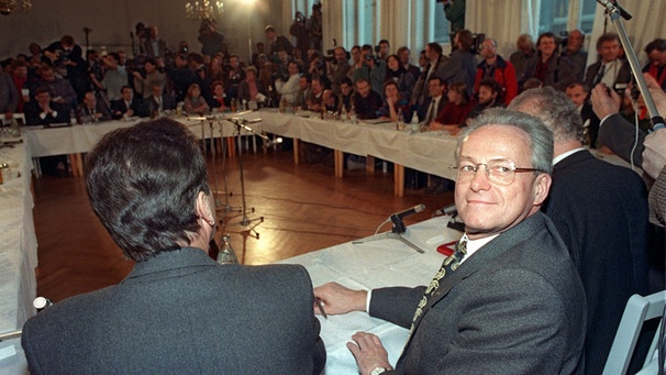 Der DDR-Staatsratsvorsitzende Manfred Gerlach (r) beim ersten Treffen des "Runden Tisches" in Ost-Berlin am 7. Dezember 1989. Die Teilnehmer beschlossen in dieser ersten Sitzung die Auflösung des Amtes für Nationale Sicherheit (Stasi) und die Durchführung von Wahlen zur Volkskammer am 6. Mai 1990.  | Bild: picture-alliance/dpa