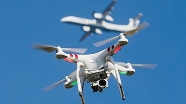 Eine private Drohne fliegt - im Hintergrund; ein Flugzeug beim Anflug auf einen Flughafen  | Bild: picture-alliance/dpa