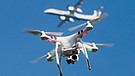Eine private Drohne fliegt - im Hintergrund; ein Flugzeug beim Anflug auf einen Flughafen  | Bild: picture-alliance/dpa