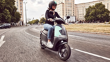 Eine Frau fährt mit einem E-Motorroller der neu gegründeten Bosch Tochter | Bild: picture-alliance/dpa