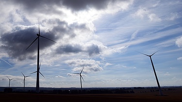 In einem Windpark drehen sich Windräder vor dunklen Wolken. | Bild: pa/dpa/Martin Schutt