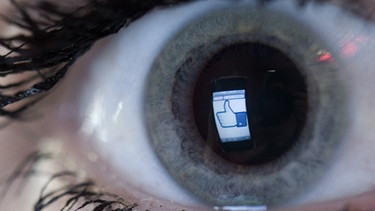 Ein Facebook-Logo spiegelt sich in einem menschlichen Auge. | Bild: picture-alliance/dpa