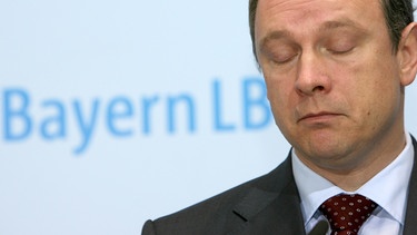 Finanzminister Georg Fahrenschon (CSU) mit geschlossenen Augen vor BayernLB-Logo | Bild: picture-alliance/dpa