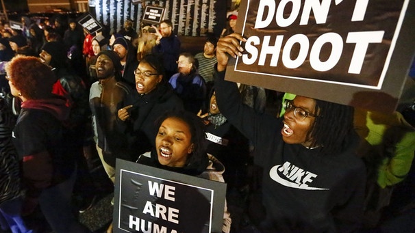 A file photo dated 10 October 2014 of people taking to the street protesting the recent police shootings of several people, outside the Ferguson Police Department headquarters in Ferguson, Missouri, USA.  | Bild: dpa-Bildfunk