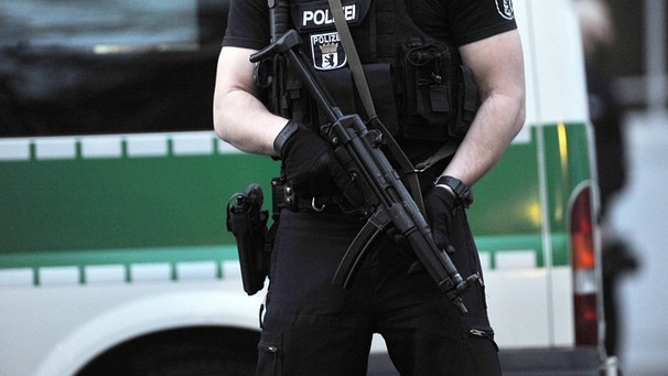 Polizist mit Maschinenpistole vor einem Berliner Haus | Bild: dpa/Bildfunk/Paul Zinken