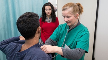 Flüchtling mit Dolmetscherin beim Arzt | Bild: picture-alliance/dpa