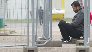Ein Asylbewerber sitzt in einer Zentralen Erstaufnahmeeinrichtung für Asylbewerber auf dem Gelände der Otto-Lilienthal-Kaserne in Roth (Bayern).  | Bild: picture-alliance/dpa