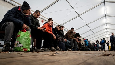 Flüchtlinge warten in einem Zelt vor dem Landesamt für Gesundheit und Soziales (LaGeSo) in Berlin auf ihre Registrierung. | Bild: picture-alliance/dpa