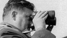 Bundesverteidigungsminister Franz Josef Strauß beobachtet am 13.09.1958 durch ein Fernglas eine Übung auf dem Truppenübungsplatz Grafenwöhr. | Bild: picture-alliance/dpa