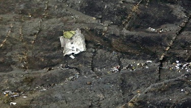  Ein Wrackteil und kleine Trümmer liegen an einem Berghang nach dem Absturz einer Maschine vom Typ Airbus A320 der Fluggesellschaft Germanwings bei Seyne Les Alpes in der Provence, Frankreich. | Bild: dpa-Bildfunk