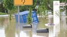  Ein Container, ein Auto und Mülltonnen schwimmen am 03.06.2013 in Rosenheim (Bayern) im Ortsteil Oberwöhr an einem überschwemmten Kreisverkehr. | Bild: picture-alliance/dpa