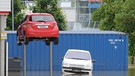 Ein Auto ragt am 03.06.2013 in Rosenheim (Bayern) im Ortsteil Oberwöhr auf einer Hebebühne am Hof eines Autohauses aus dem Wasser. | Bild: picture-alliance/dpa