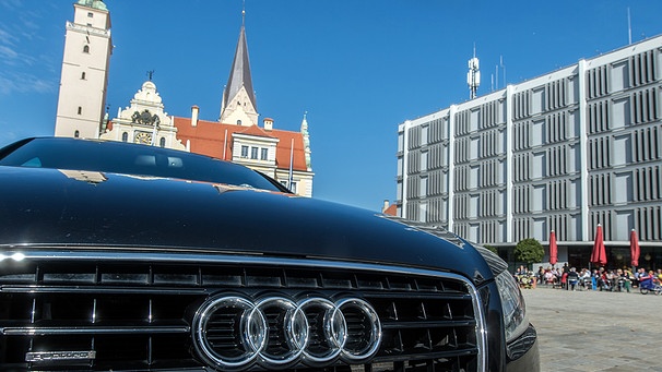 Ein Audi steht in Ingolstadt vor dem alten (l.) und neuen Rathaus.  | Bild: picture-alliance/dpa/Armin Weigel
