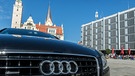 Ein Audi steht in Ingolstadt vor dem alten (l.) und neuen Rathaus.  | Bild: picture-alliance/dpa/Armin Weigel