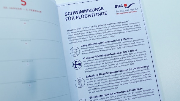 Das Foto vom 30.11.2016 in Berlin zeigt eine Seite aus dem "Almanach" zum diesjährigen Bundespresseball. Die Satire über Schwimmkurse für Flüchtlinge im Mittelmeer hat Wirbel unter den Hauptstadtjournalisten ausgelöst. | Bild: dpa-Bildfunk/Kay Nietfeld