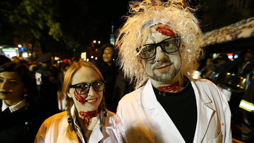 People wearing costumes walk at the Sixth Avenue as they celebrate the Halloween in New York, United States. | Bild: picture-alliance/dpa