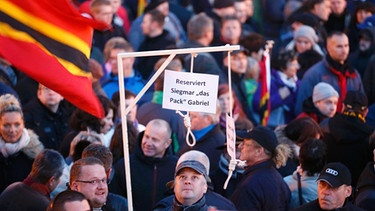 Personen halten einen Galgen mit der Aufschrift "Reserviert Siegmar "das Pack" Gabriel" bei einer Demo in Dresden. | Bild: Reuters (RNSP) / Hannibal Hanschke