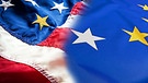 Eine amerikanische und eine EU-Flagge bei denen jeweils die Farbe eines Sterns ausgetauscht wurde | Bild: colourbox.com; Montage: BR