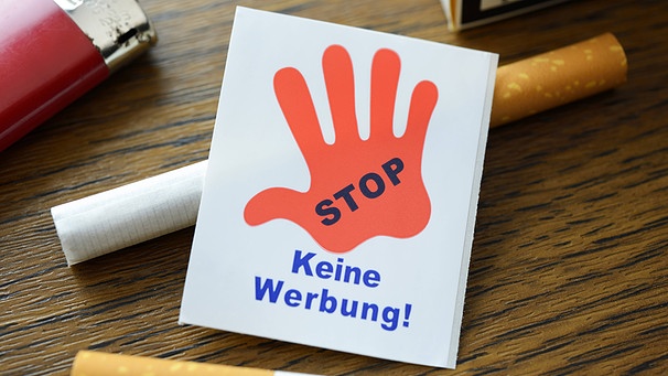 Zigaretten und Papierstück mit roter Hand und Aufschrift "Stop - keine Werbung" | Bild: imago/Christian Ohde