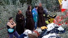 Friars stand with two women in front of collapsed house following an earthquake in Pescara del Tronto | Bild: Reuters (RNSP)/Remo Casilli