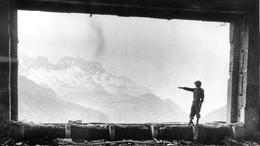 Kriegsende 1945: US-Soldat steht im Panoramafenster des ausgebrannten Berghofes | Bild: picture-alliance/dpa