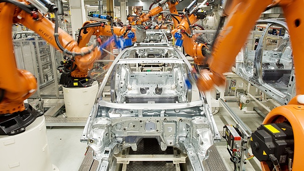 Roboter der Firma Kuka arbeiten im VW-Werk in Wolfsburg (Niedersachsen) an einer Produktionsstraße | Bild: picture-alliance/dpa