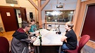 Drei Schüler sitzen an einem Tisch im Rundfunkstudio | Bild: BR