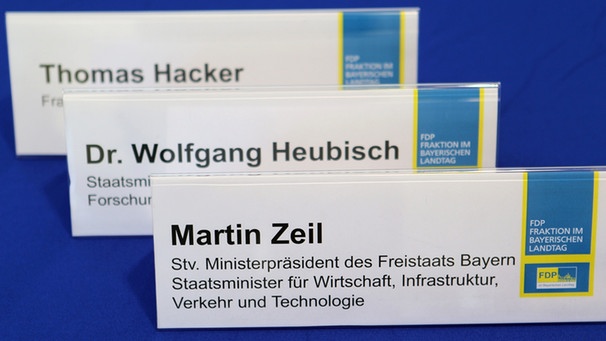 Die Namensschilder des bayerischen Wirtschaftsministers Zeil (FDP), des FPD-Fraktionsvorsitzenden Hacker und des bayerischen Wissenschaftsministers Heubisch (FDP) (Archiv) | Bild: picture-alliance/dpa