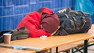 Eine Frau schläft am 31.10.2015 in Neuhaus am Inn (Bayern) nach der Überquerung der österreichisch-deutschen Grenze in einer Versorgungsstation für Flüchtlinge. | Bild: dpa-Bildfunk