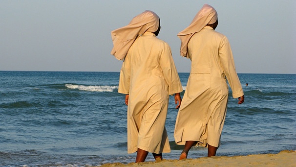 Zwei Nonnen barfuß an einem Strand an der Adria in Italien | Bild: picture-alliance/dpa/Lars Halbauer