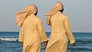 Zwei Nonnen barfuß an einem Strand an der Adria in Italien | Bild: picture-alliance/dpa/Lars Halbauer