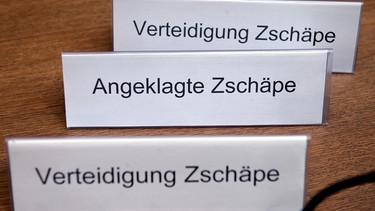 Zwei Tischschilder mit der Aufschrift «Verteidigung Zschäpe» und eines mit der Aufschrift «Angeklagte Zschäpe» | Bild: picture-alliance/dpa
