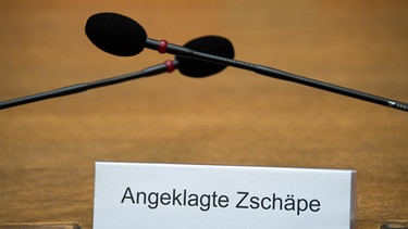 Ein Schild mit der Aufschrift "Angeklagte Zschäpe" steht auf der Anklagebank im Gerichtssaal im Oberlandesgericht in München (Bayern). | Bild: picture-alliance/dpa/Peter Kneffel