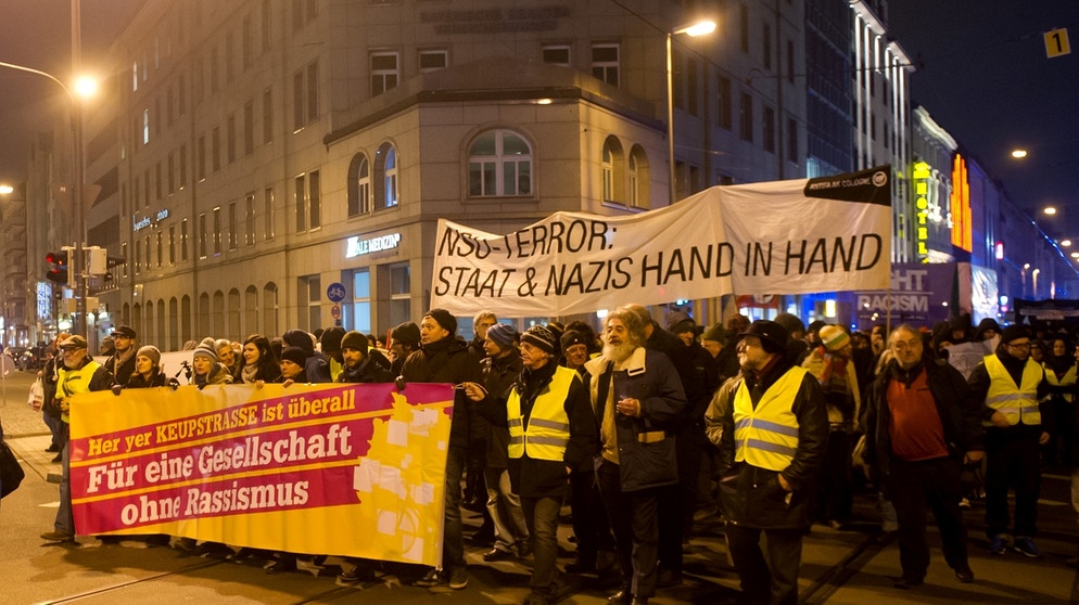 Demonstranten gehen in München auf der Dachauer Straße und tragen Transparente mit der Aufschrift: "Für eine Gesellschaft ohne Rassismus" und "NSU-Terror: Staat und Nazis Hand in Hand". Die Initiative "Keupstraße ist überall" hat zu der Demonstration aufgerufen, um sich gegen Rassismus und Fremdenfeindlichkeit zu stellen und auf eine lückenlose Aufklärung der Morde und Anschläge des NSU zu dringen  | Bild: picture-alliance/dpa
