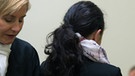 Die Angeklagte Beate Zschäpe von hinten im Gerichtssaal in München zwischen ihren Anwälten  | Bild: picture-alliance/dpa