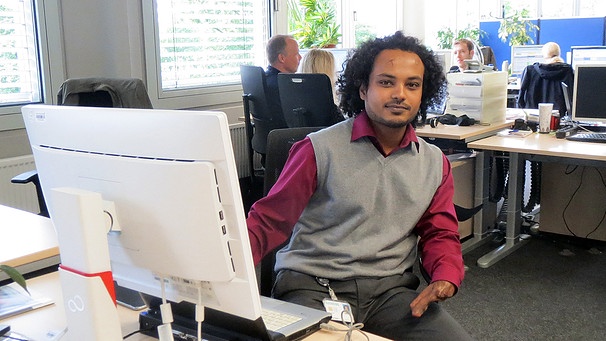 Filmon Debru an seinem Schreibtisch bei Siemens | Bild: BR/Christine Gaupp