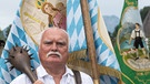 Als der historische "Schmied von Kochel" trägt ein Mann eine Marien-Fahne an Maria Himmelfahrt am 15.08.2016 beim Großen Trachtenfestzug durch Kochel am See (Bayern). | Bild: dpa-Bildfunk/Peter Kneffel