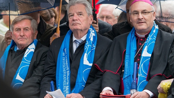 Bundespräsident Joachim Gauck (M) sitzt am 28.05.2014 in Regensburg (Bayern) während der Eröffnungsfeier des Katholikentags neben dem Präsidenten des Zentralkomitees der deutschen Katholiken (ZdK), Alois Glück (l) und dem Regensburger Bischof Rudolf Voderholzer. | Bild: picture-alliance/dpa
