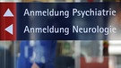 in Schild mit der Aufschrift "Anmeldung Psychiatrie" und "Anmeldung Neurologie" ist an einem Gebäude im Bezirksklinikum in Regensburg (Oberpfalz) angebracht.  | Bild: picture-alliance/dpa