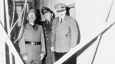 Noch am gleichen Tag nach dem mißglückten Attentat von Graf Stauffenberg zeigt Hitler Mussolini, der zum Besuch im Führerhauptquartier eintraf, die Trümmer der Baracke nach der Explosion in der Wolfsschanze. | Bild: SZ Photo